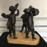 Three musician angels, bronze sculptures on a marble base.
