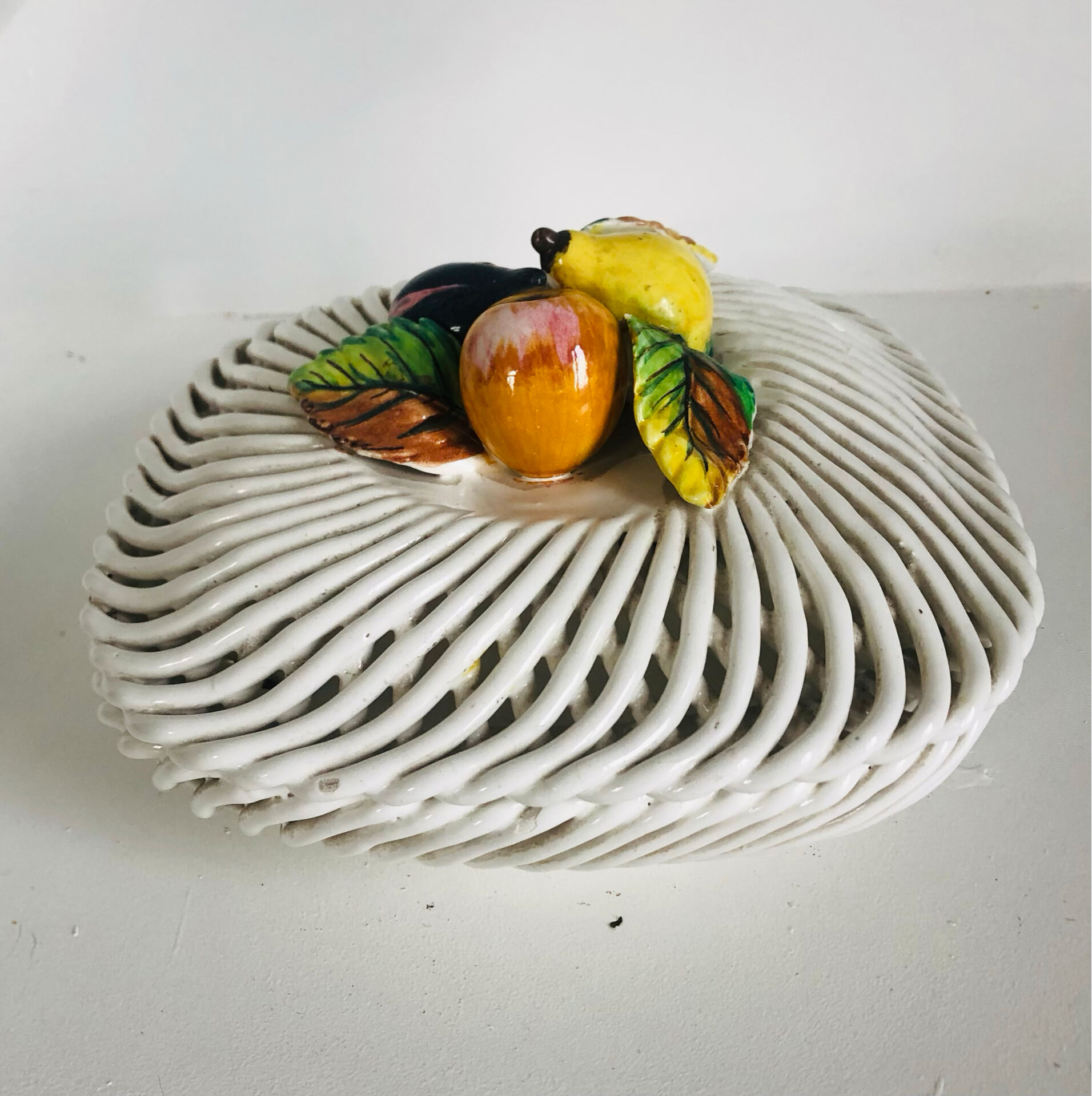 Covered basket in white woven ceramic and fruit slip.