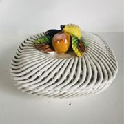 Covered basket in white woven ceramic and fruit slip.