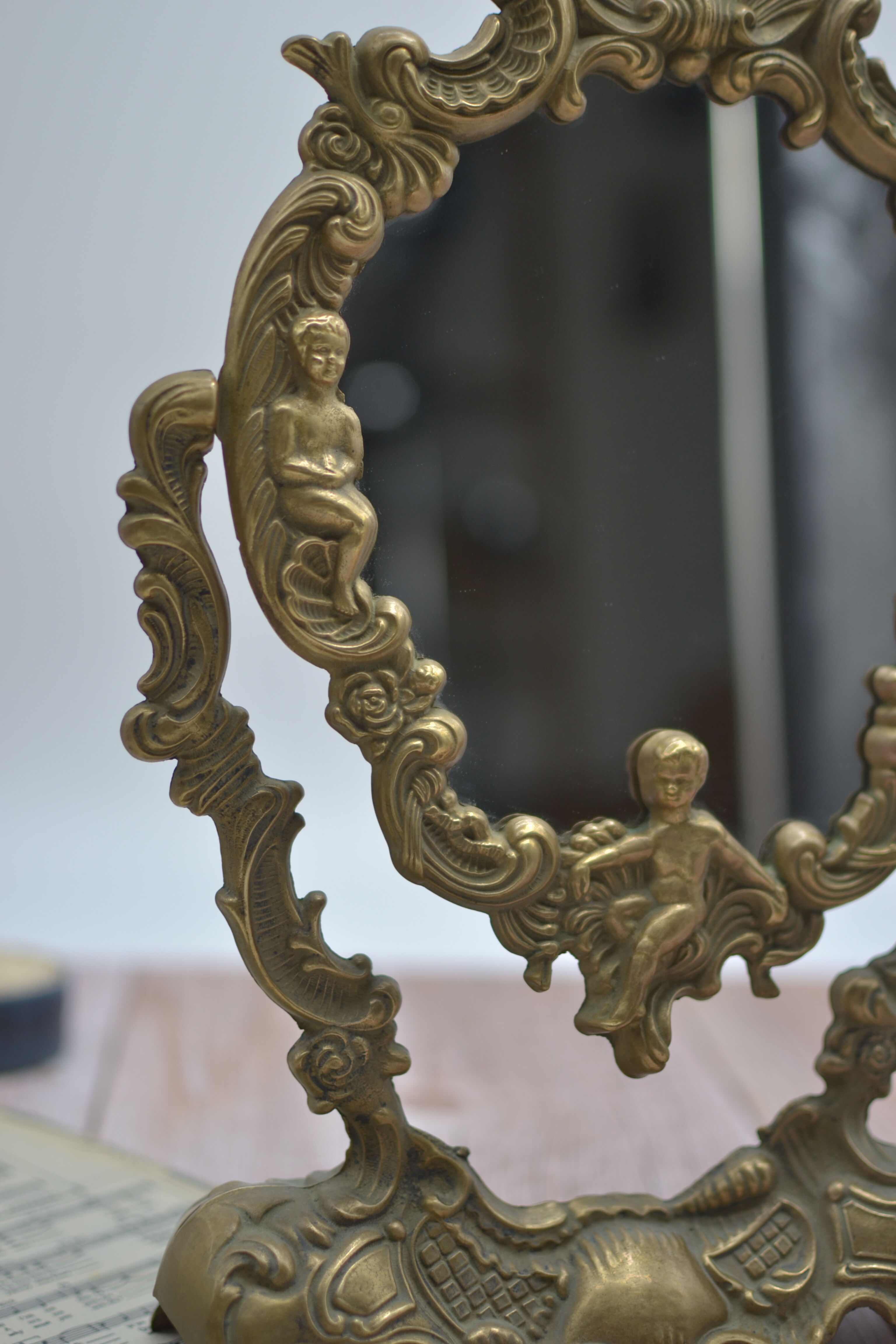 Adjustable psyche mirror of 33 centimeters in gilded bronze with angel ornament