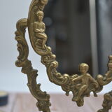 Adjustable psyche mirror of 33 centimeters in gilded bronze with angel ornament