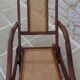 Antique folding chair with caned seat and backrest made of wood.