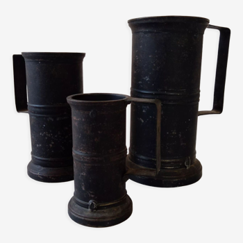 Set of three black patinated steel tankards with engraved initials and welds stamped B