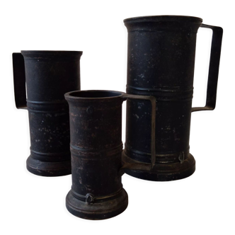 Set of three black patinated steel tankards with engraved initials and welds stamped B