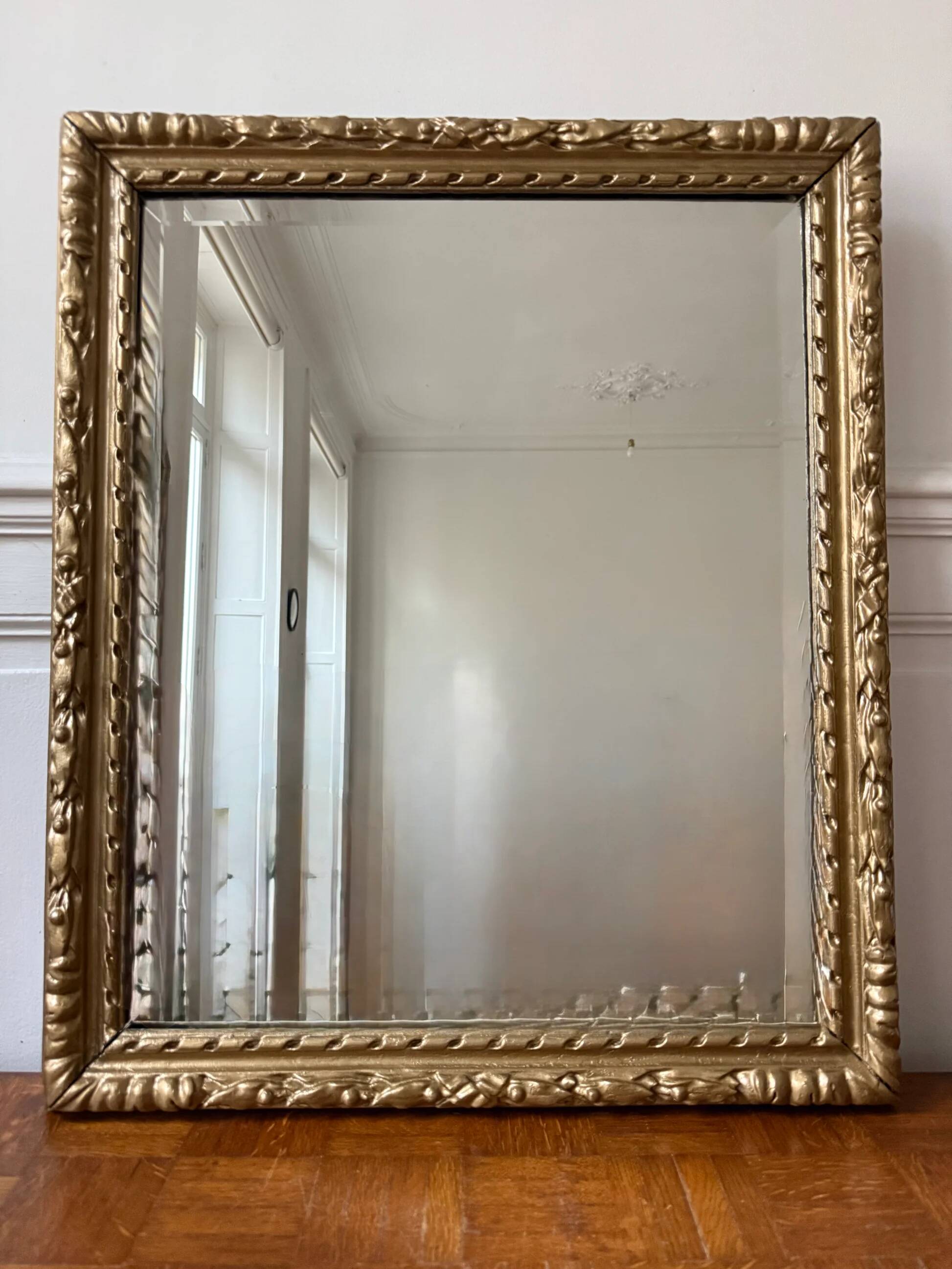 Bevelled mirror in carved gilded wood