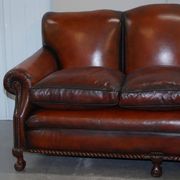Restored Victorian sofa in leather with claw feet and feather cushions.