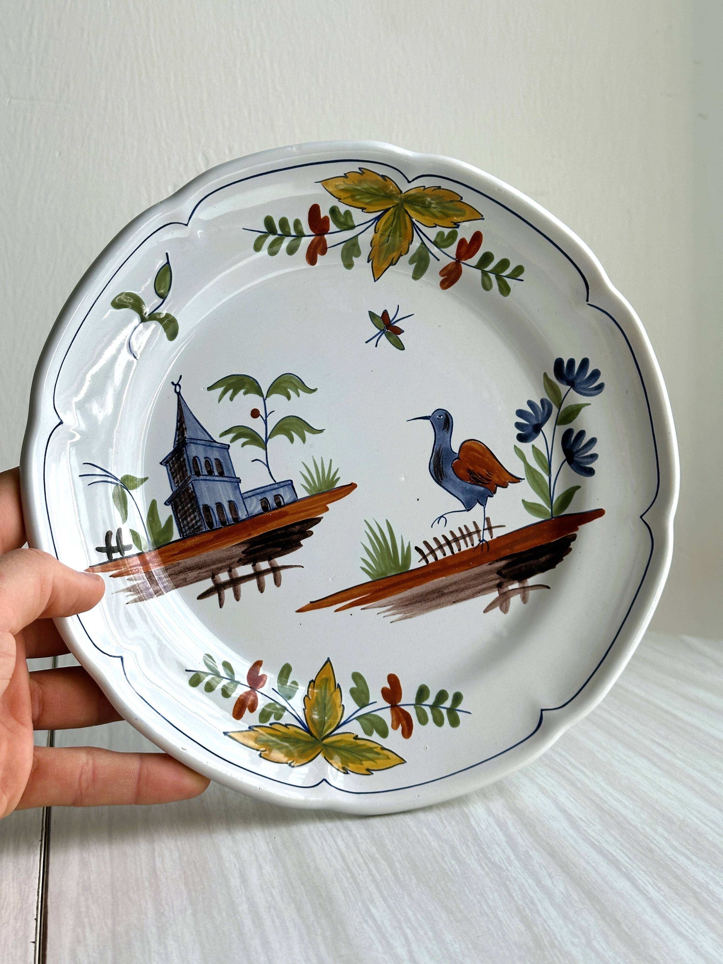 Hand-painted earthenware plate with landscape and bird decoration.