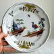Hand-painted earthenware plate with landscape and bird decoration.