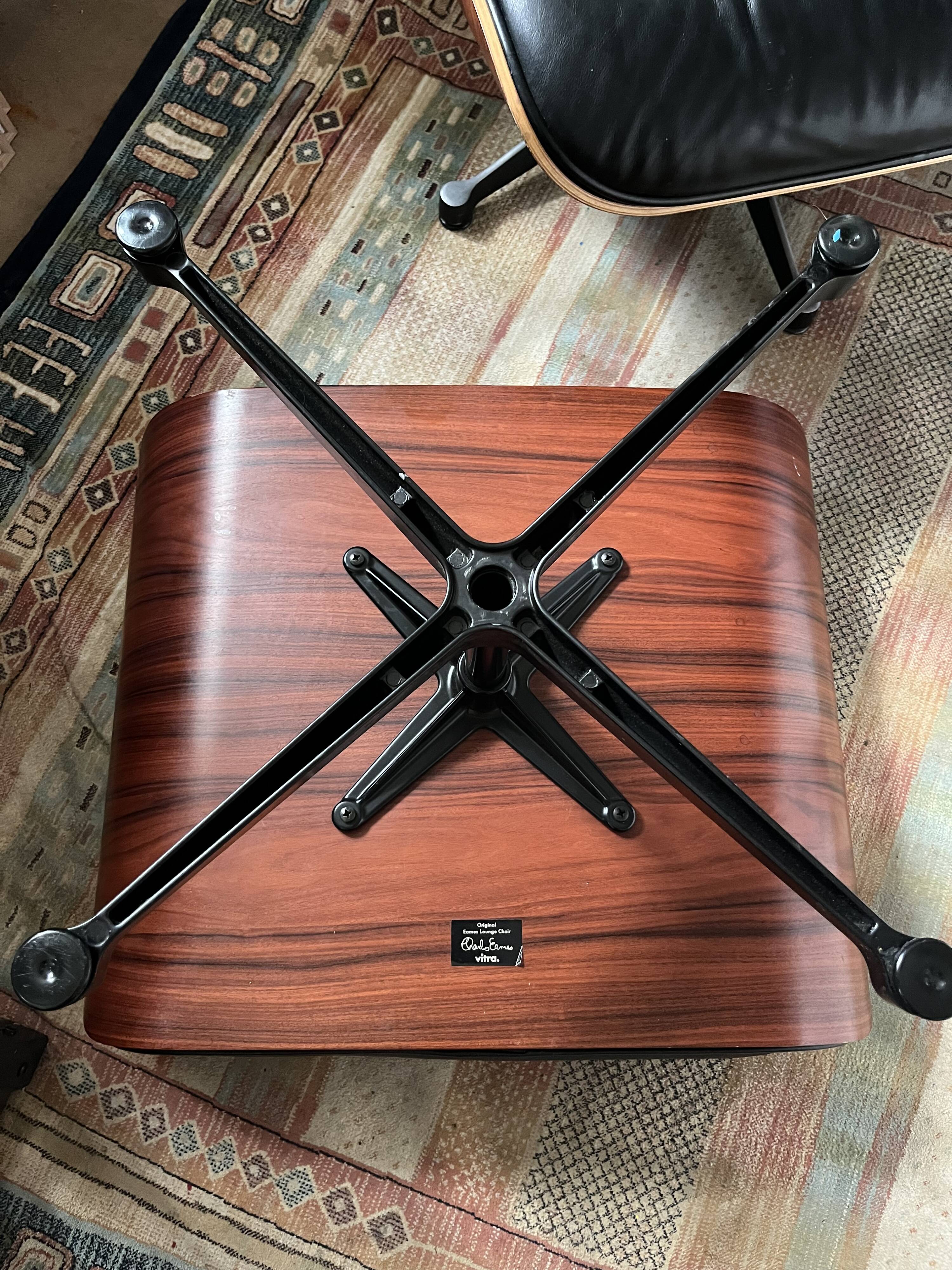 Black leather Eames Vitra armchair, original with rosewood ottoman.