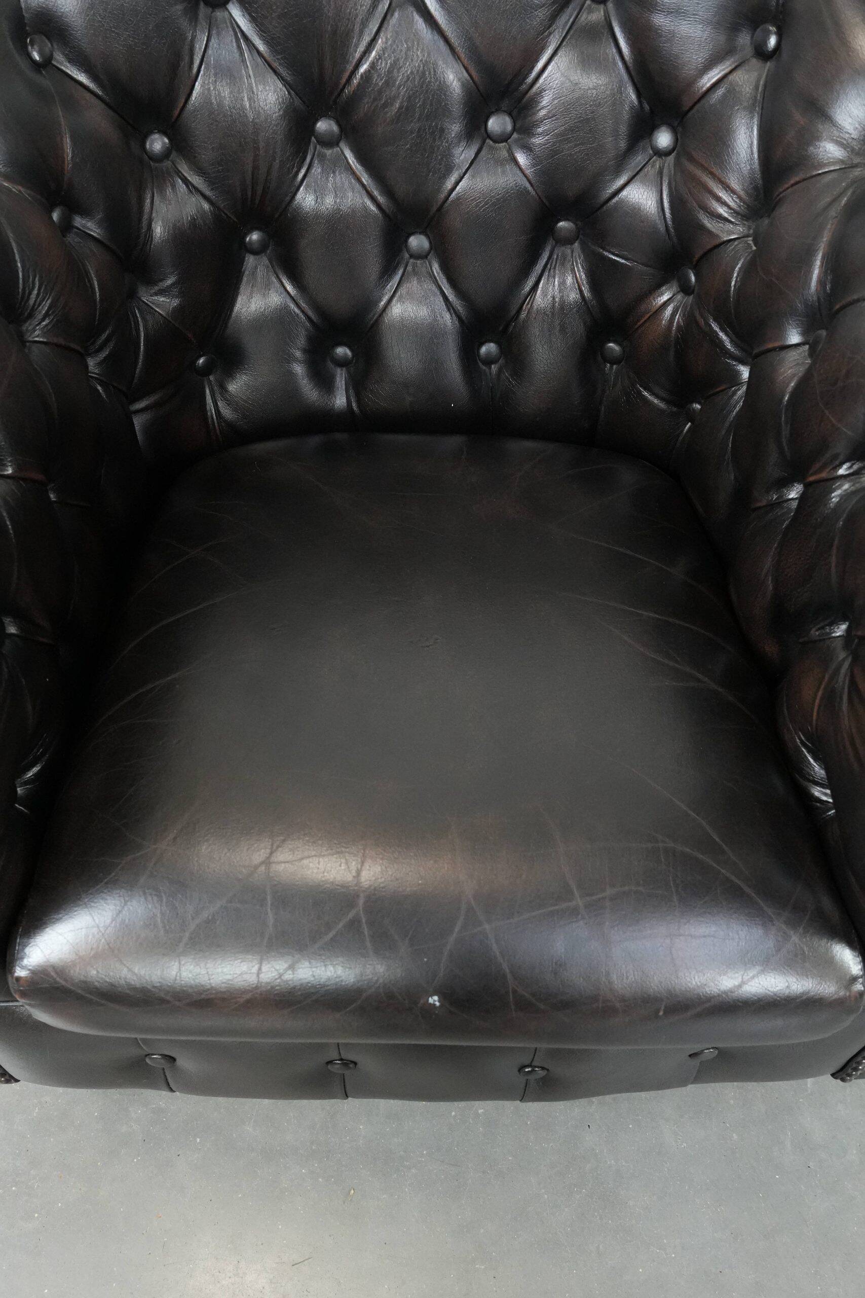Ensemble de deux luxueux fauteuils club Chesterfield en cuir de vachette noir.