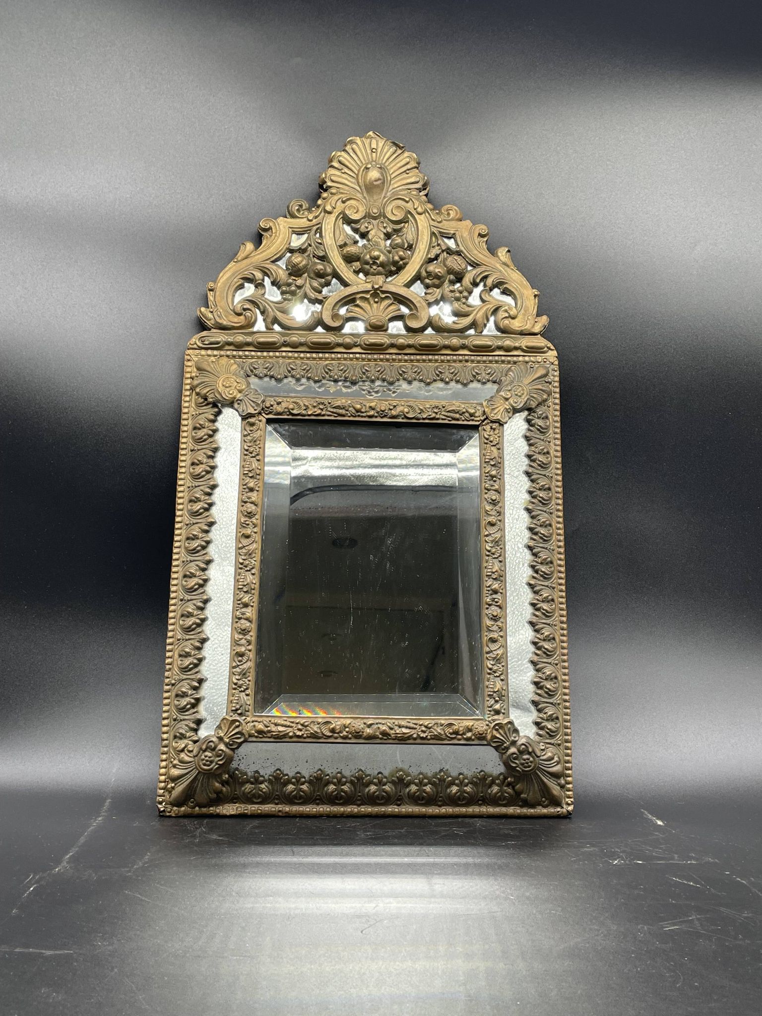 Small mirror with brass parcloses in repoussé style Louis XIV, late 19th century.