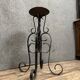 Wrought iron candlestick on four-legged base circa 1900-1930
