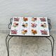 Vintage coffee table in wrought iron with floral tiles.