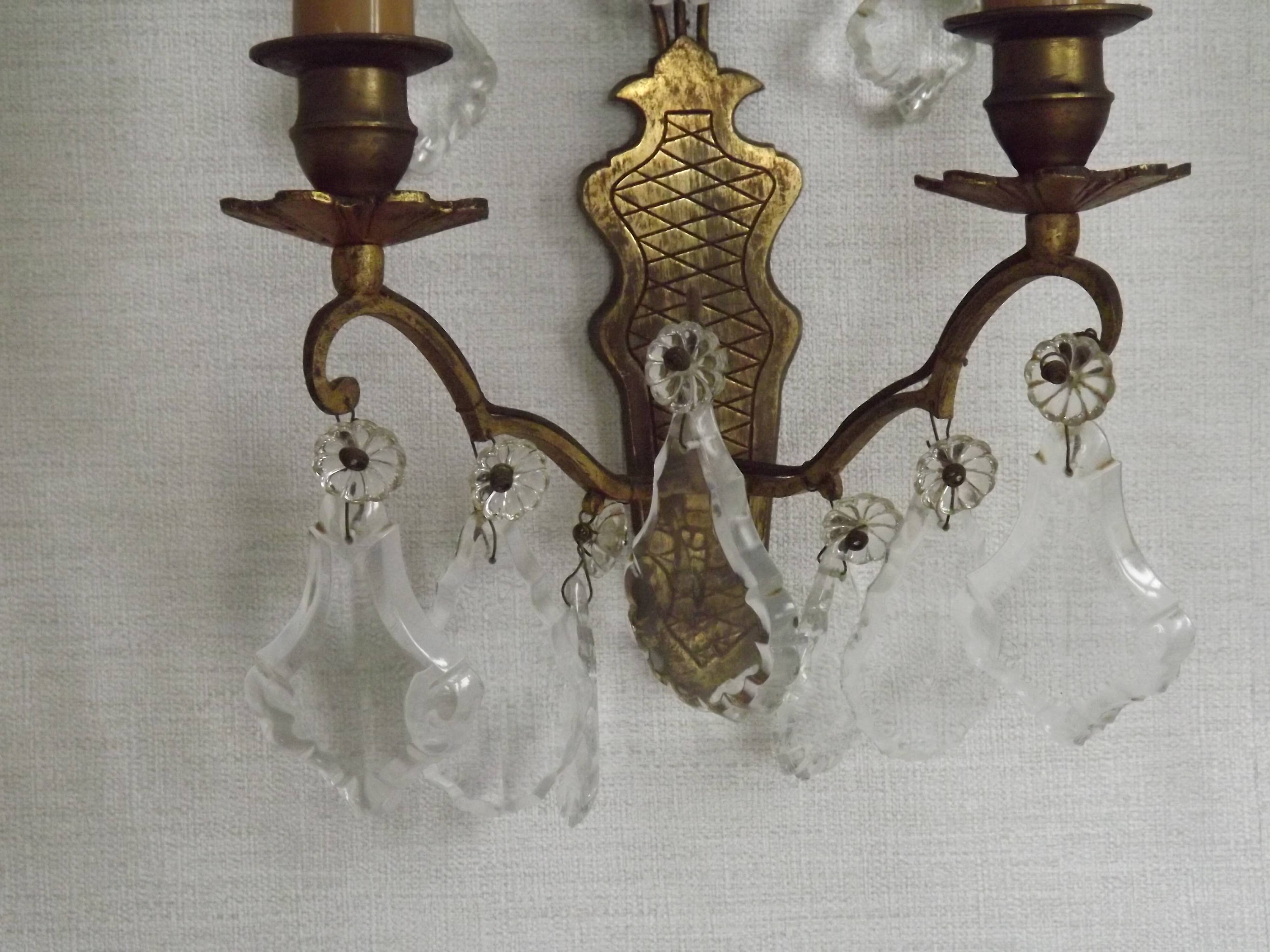 Pair of French antique brass double wall lights with assorted crystals.