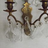 Pair of French antique brass double wall lights with assorted crystals.