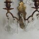 Pair of French antique brass double wall lights with assorted crystals.