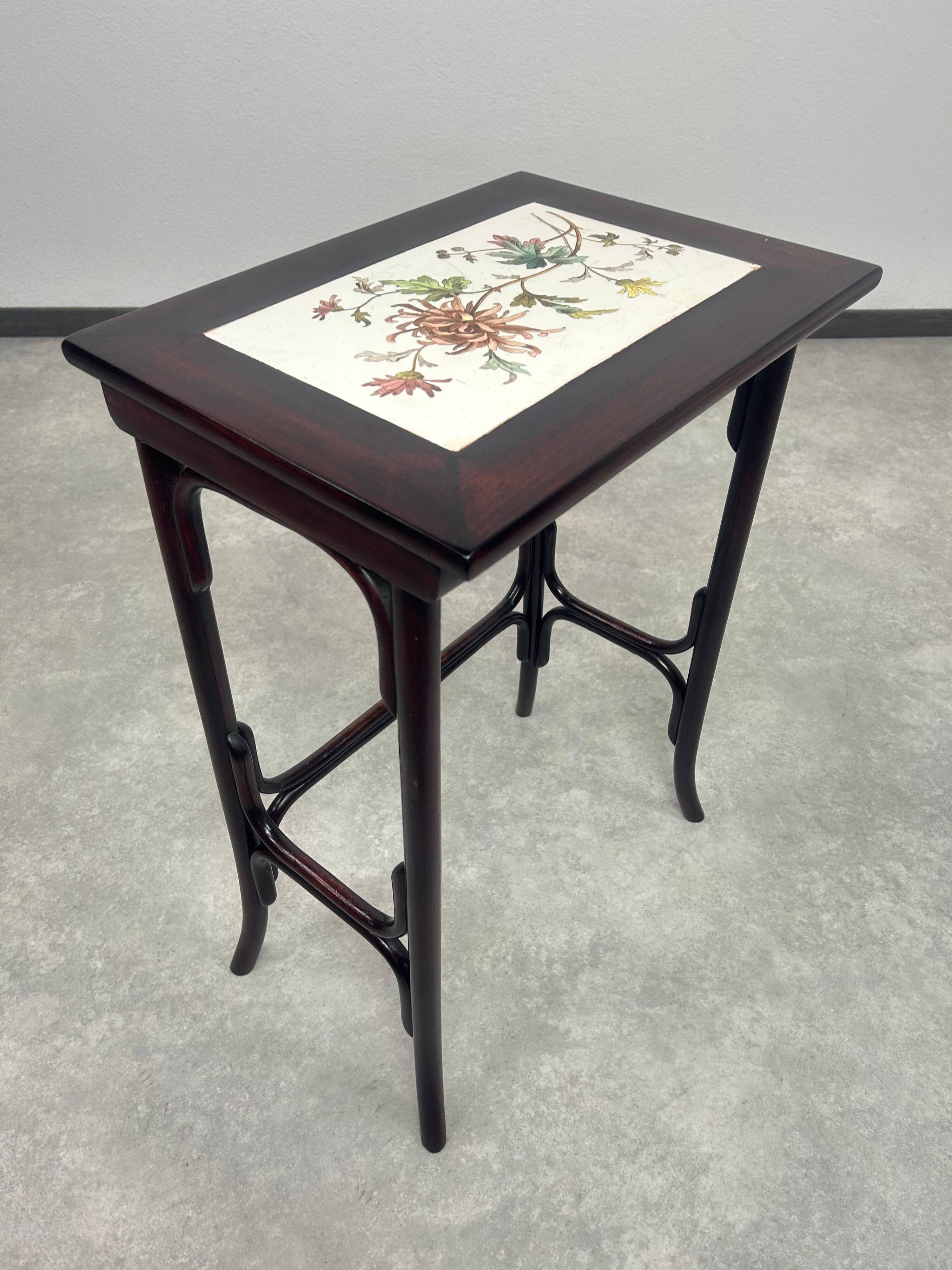 Nested tables in curved wood with ceramic top by Thonet.