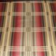 Very large worn sheepskin wing chair with a checked seat cushion
