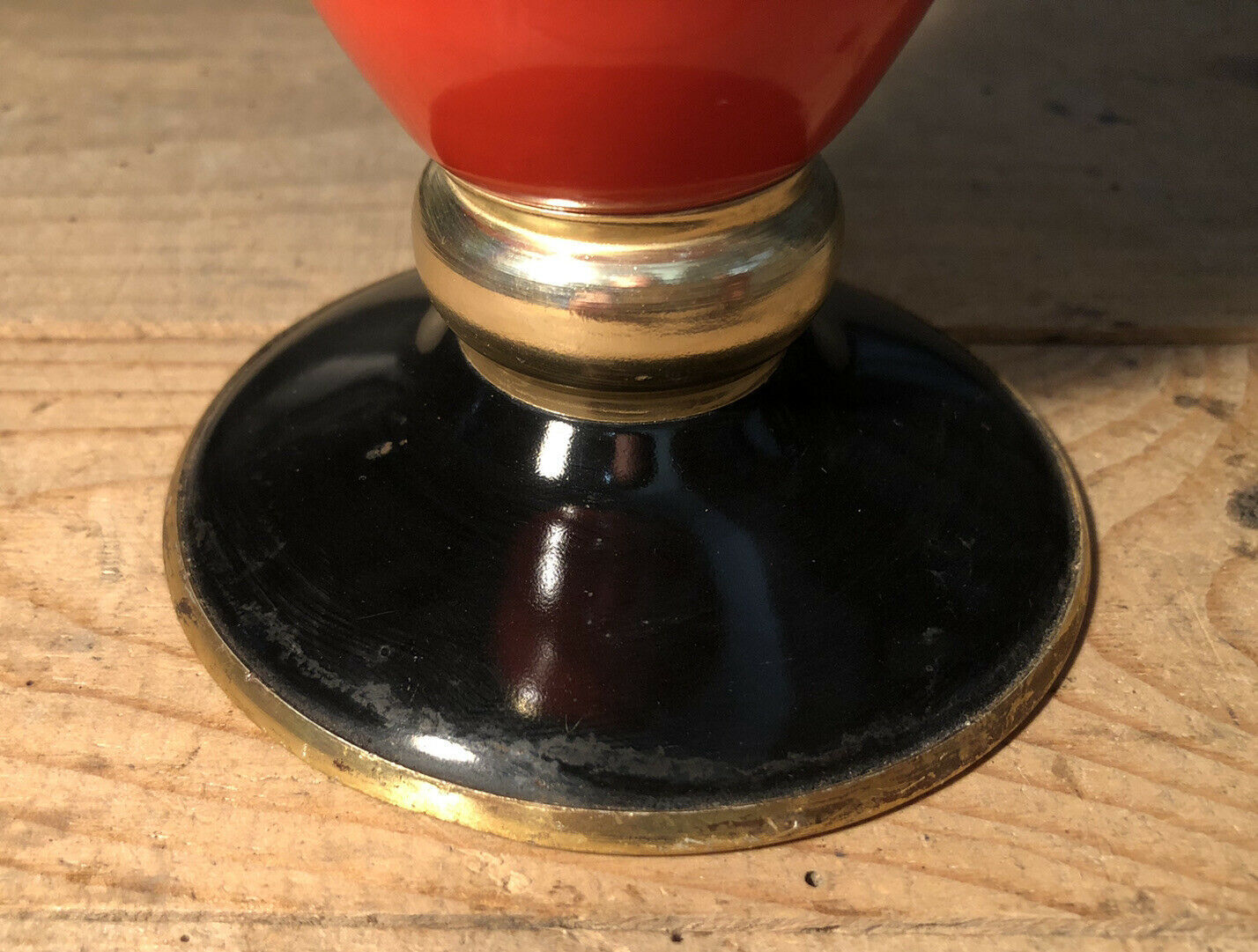 Cut vase on foot in red and black metal