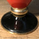 Cut vase on foot in red and black metal