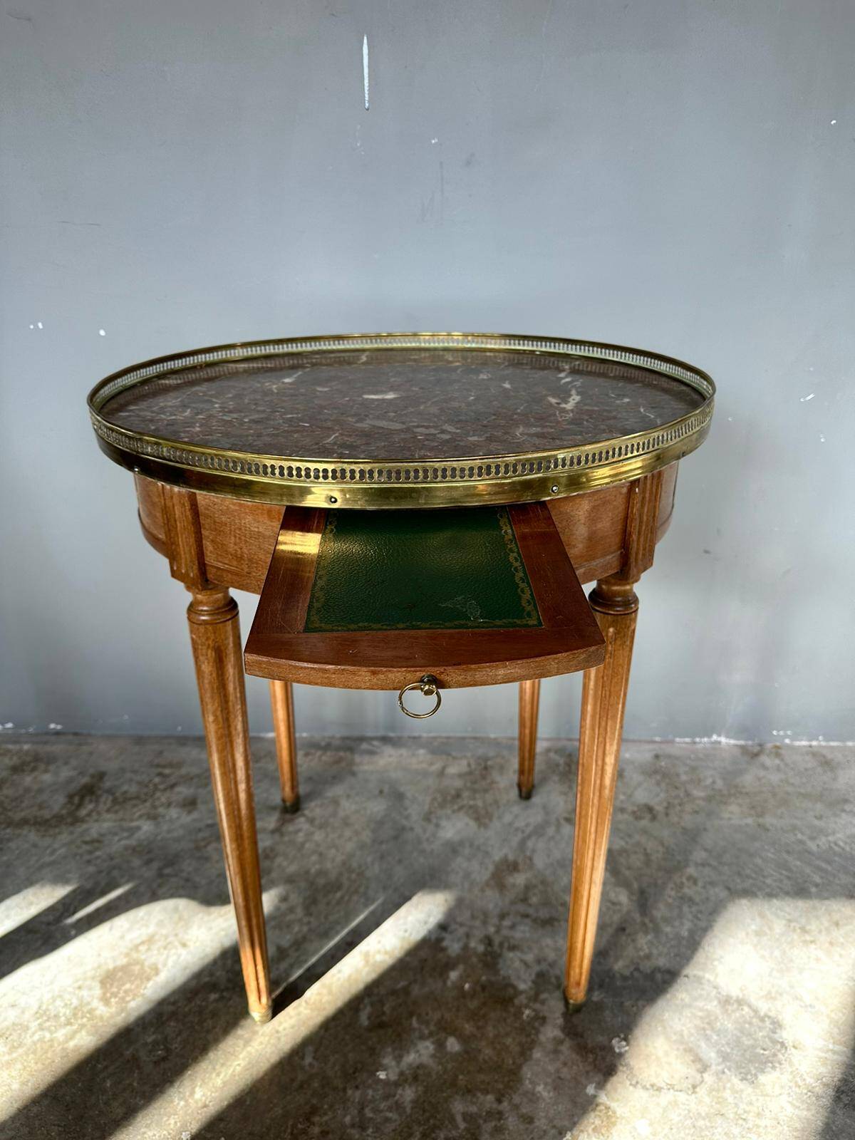 Hot water bottle table with a marble top and a brass gallery.