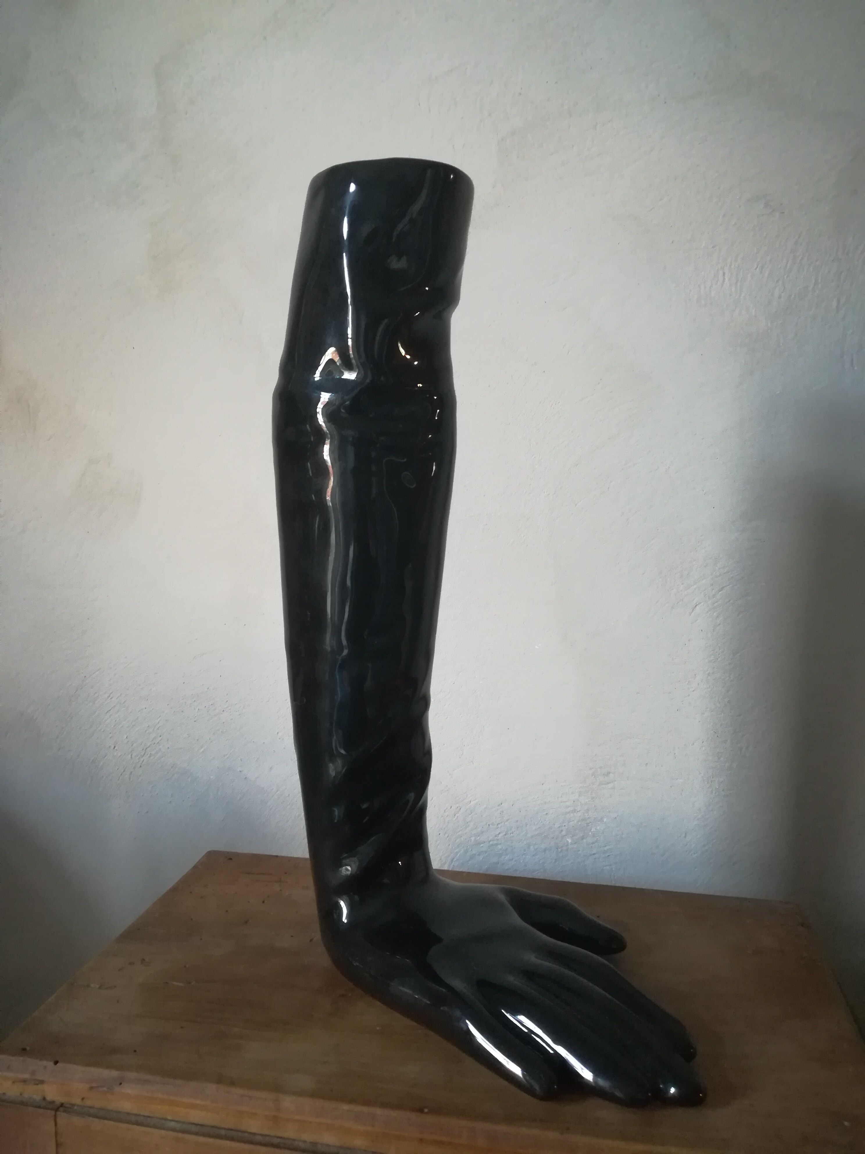 Black earthenware vase gloved hand