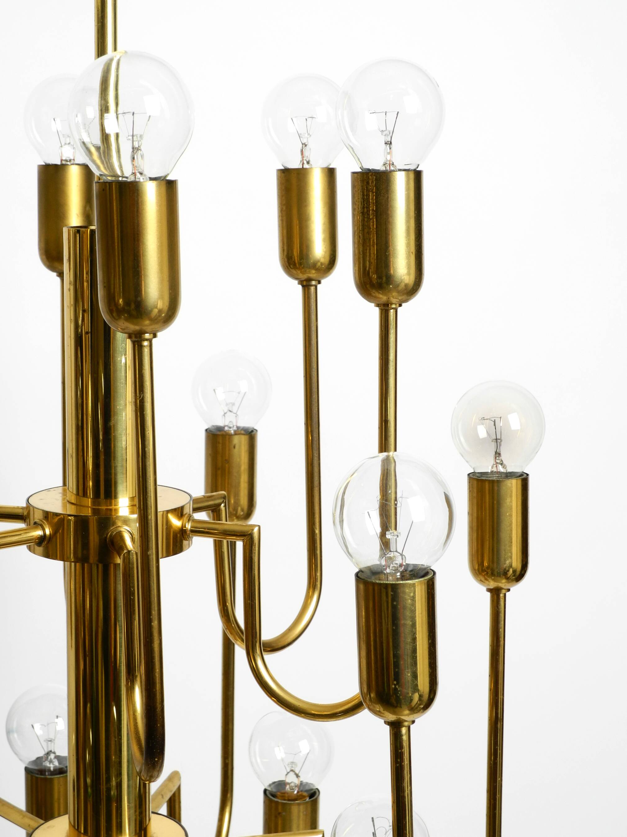 Three staged 18 arm Mid Century brass chandelier with a long brass rod