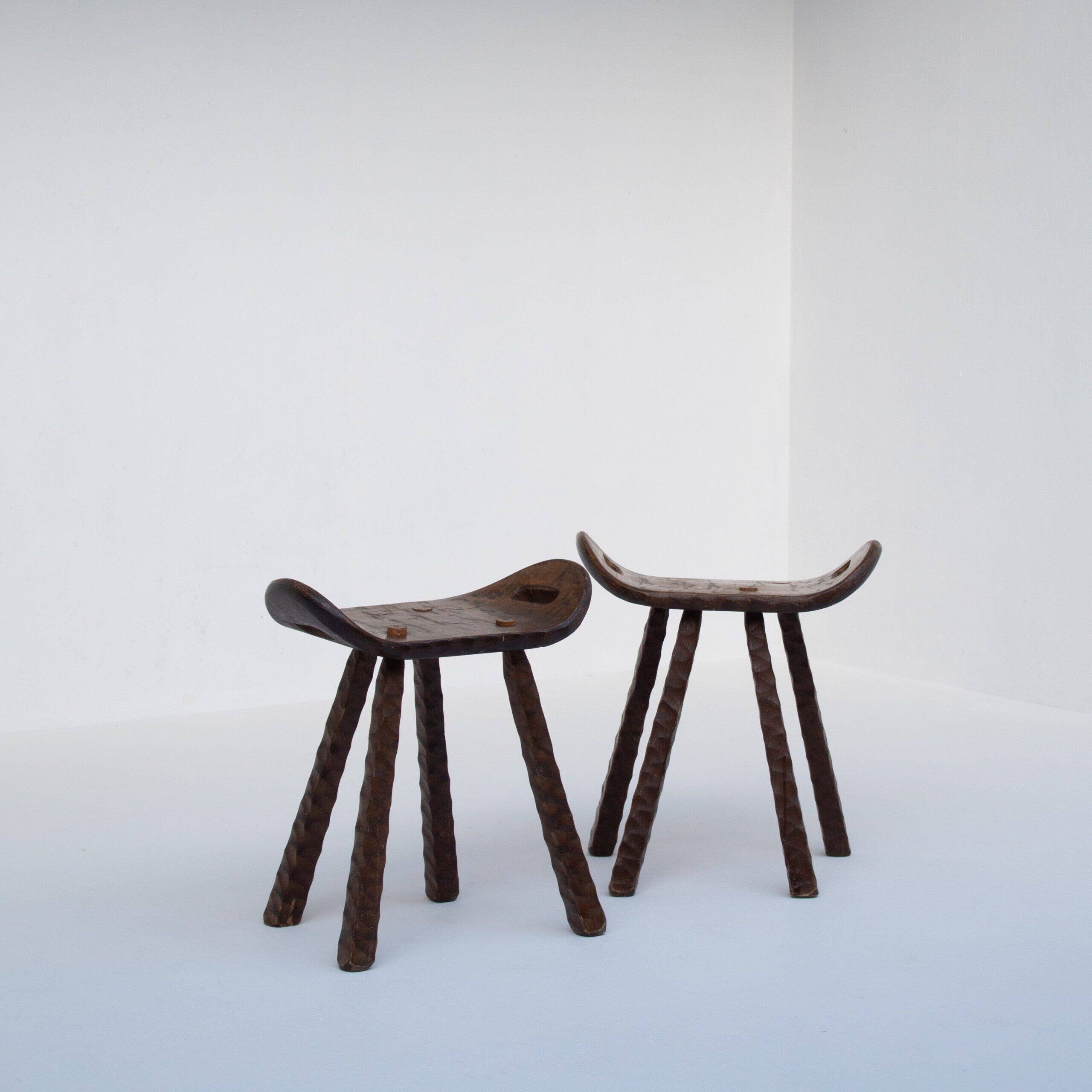 Ensemble de deux tabourets en bois sculptés à la main avec poignées.
