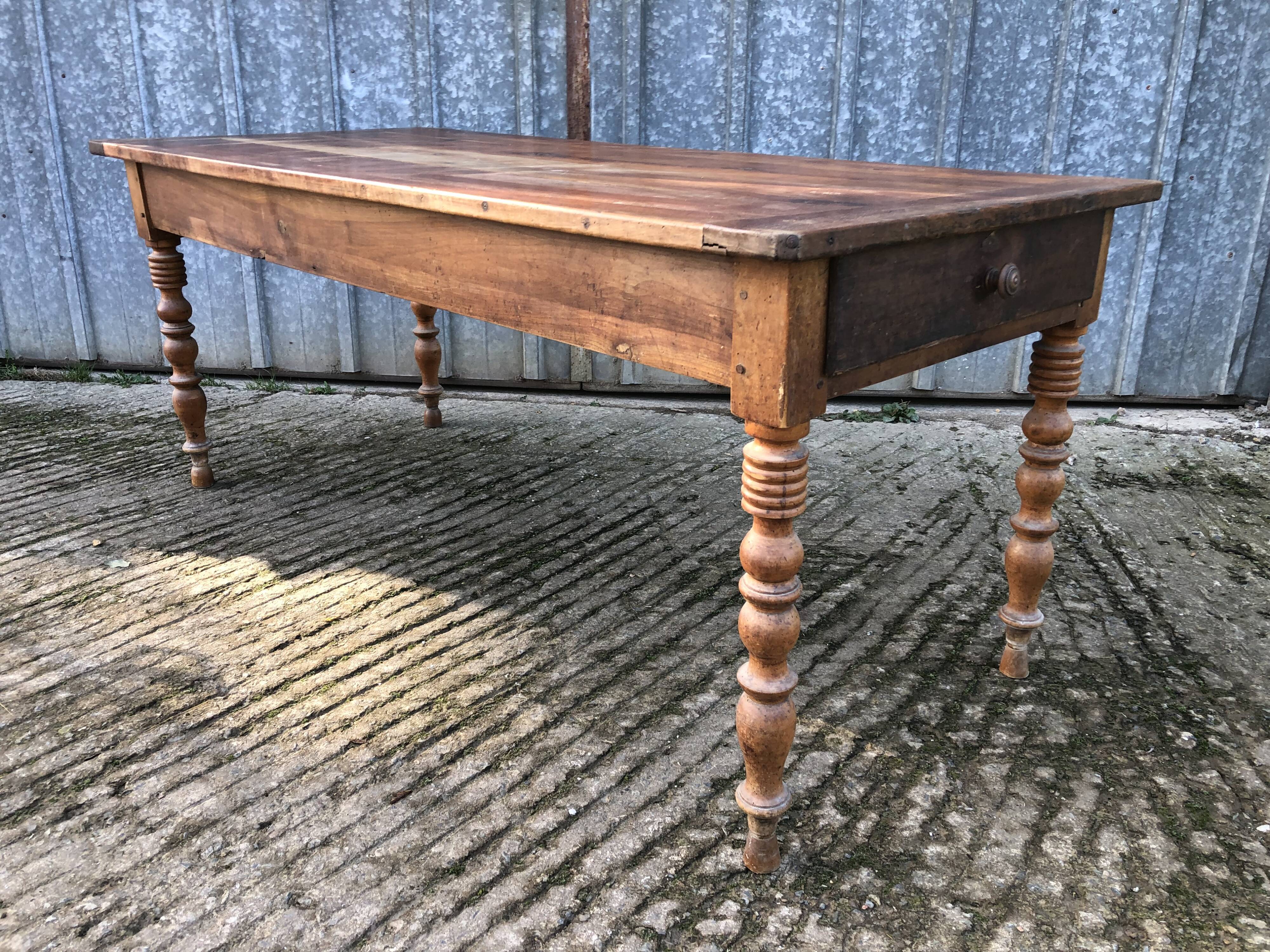 Antique farmhouse table in solid cherry wood with turned legs.