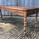Antique farmhouse table in solid cherry wood with turned legs.