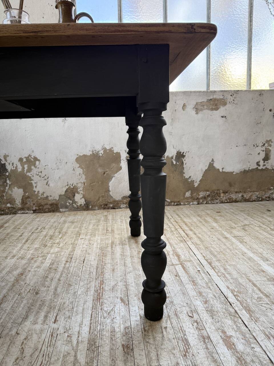 Oak farmhouse table with turned black legs.