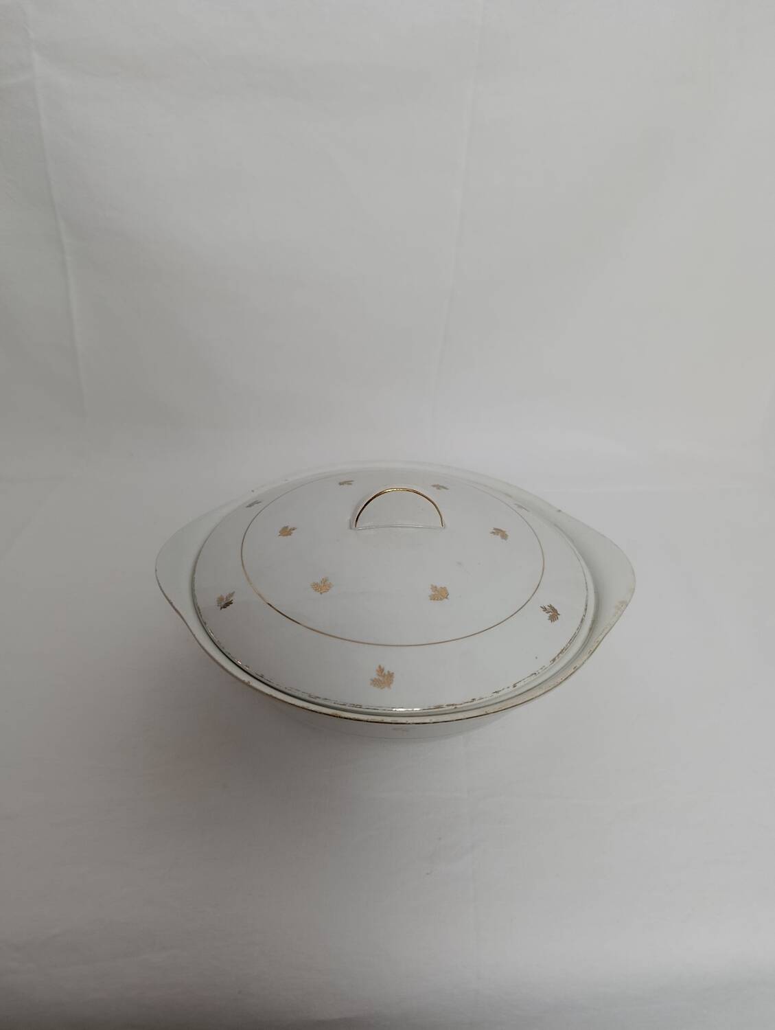 White earthenware soup tureen with a golden pattern.
