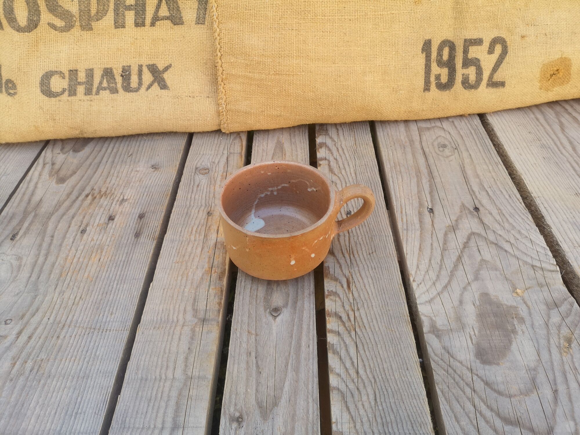 Brown sandstone cup with white spots