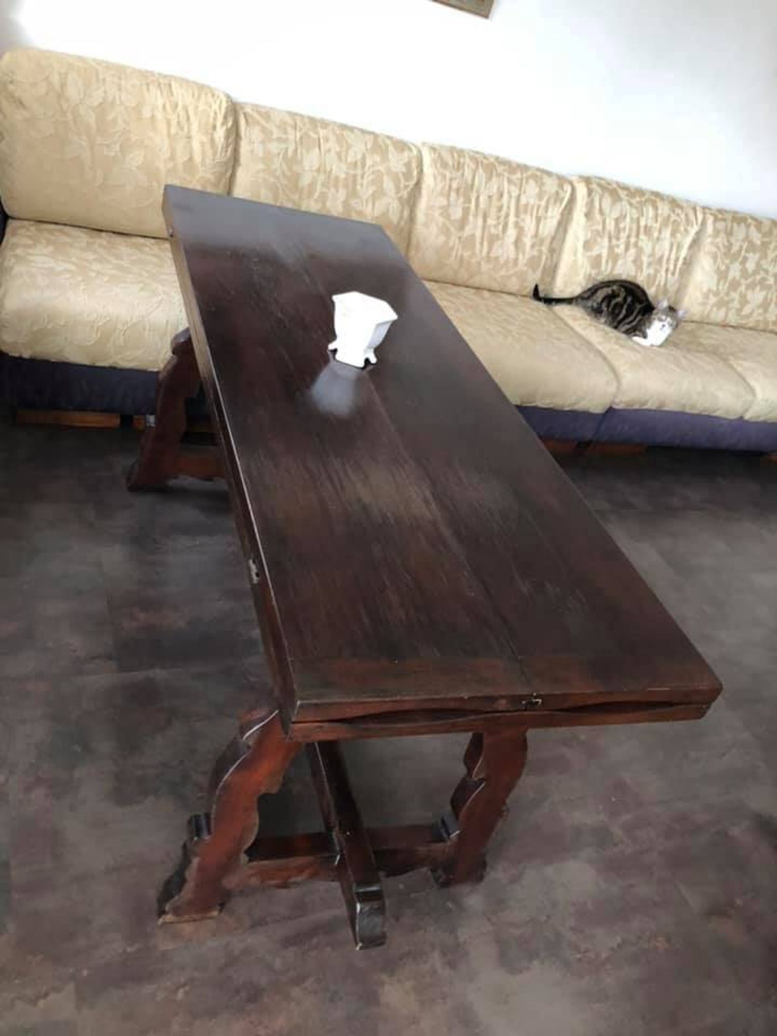 19th-century brown walnut dining table with sculpted trestle legs.