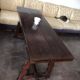 19th-century brown walnut dining table with sculpted trestle legs.