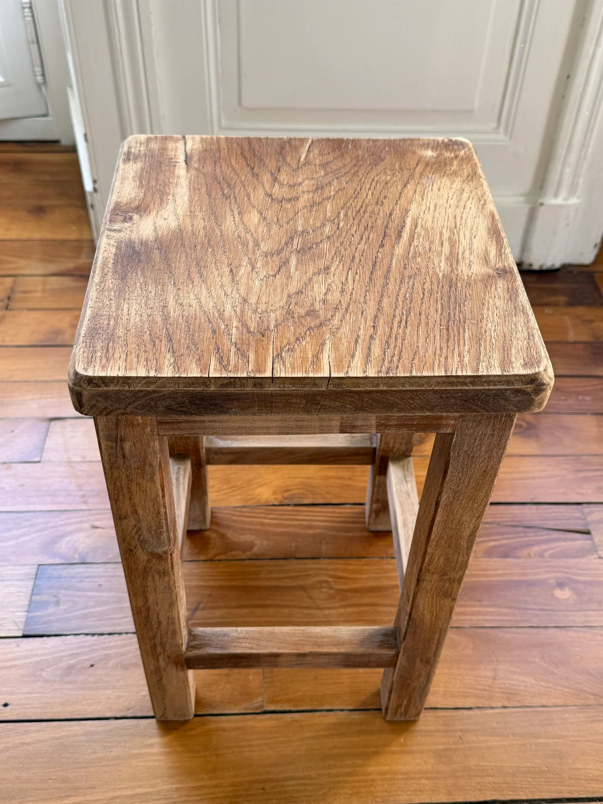 Brutalist stool in raw wood with a weathered effect.