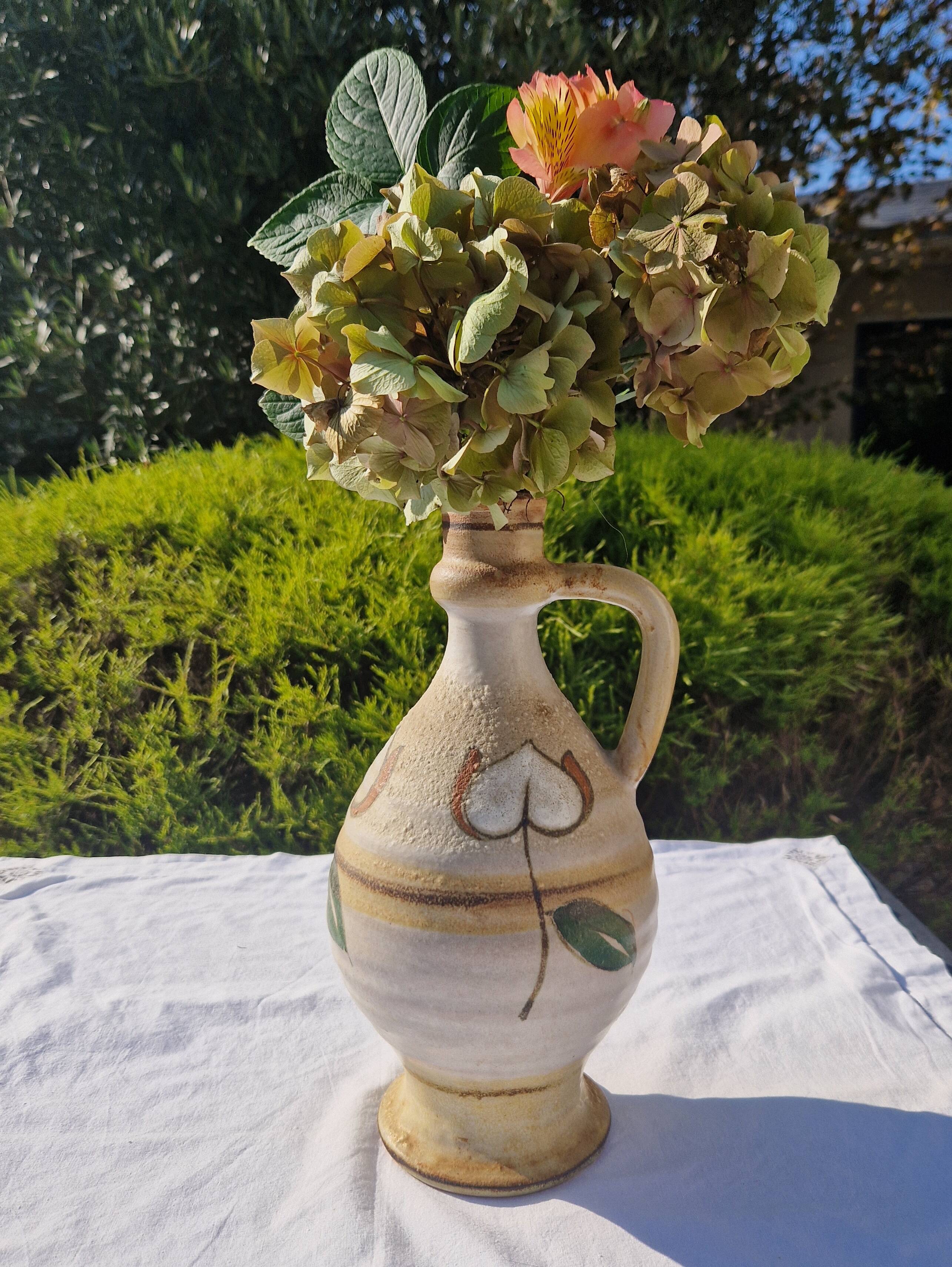 Handcrafted jug or jar with a handle, terracotta pottery vase, fat lava effect, stylized flowers