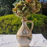 Handcrafted jug or jar with a handle, terracotta pottery vase, fat lava effect, stylized flowers