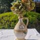 Handcrafted jug or jar with a handle, terracotta pottery vase, fat lava effect, stylized flowers