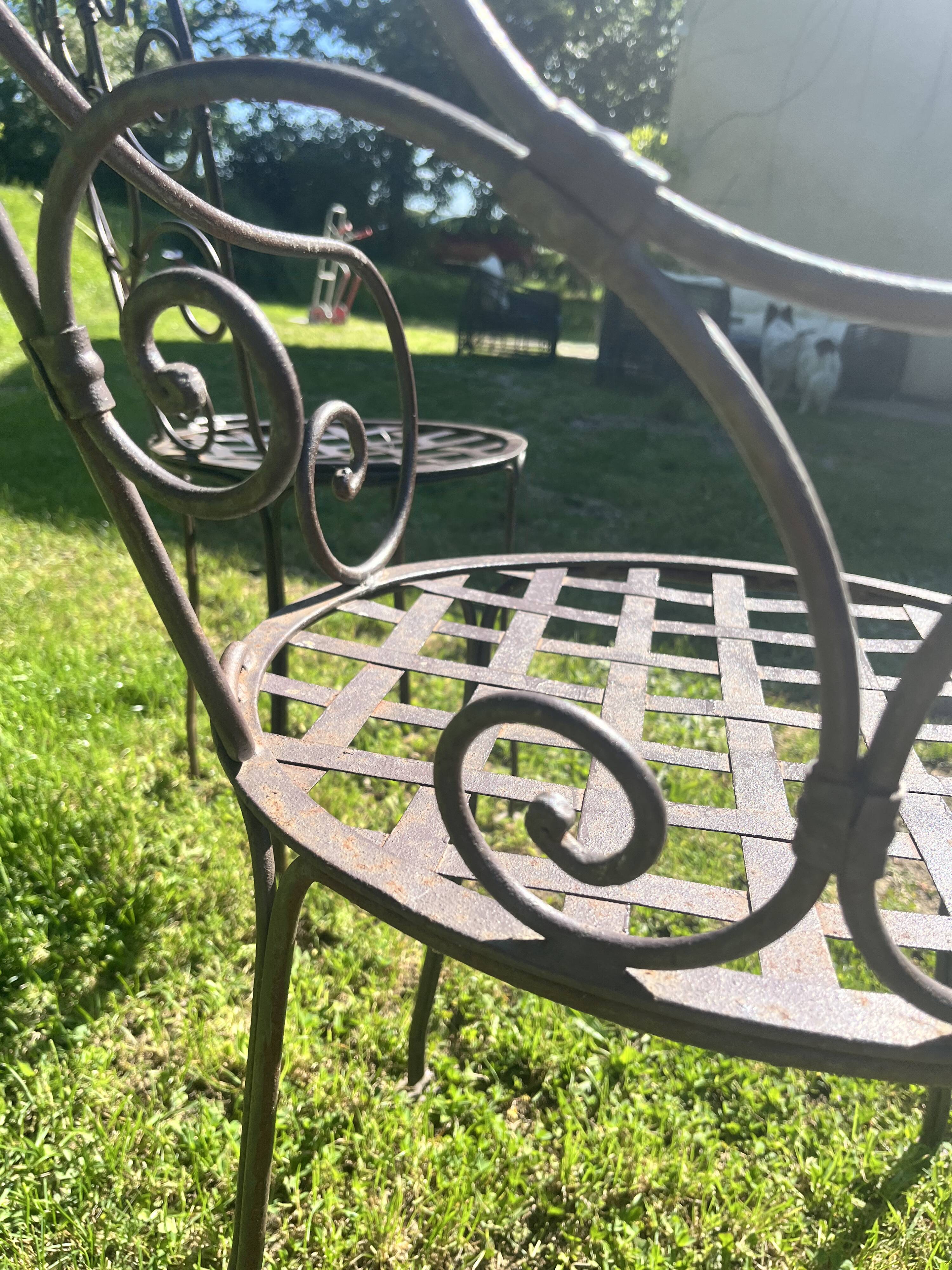 Old wrought iron table and its armchairs and chairs for outdoor use.
