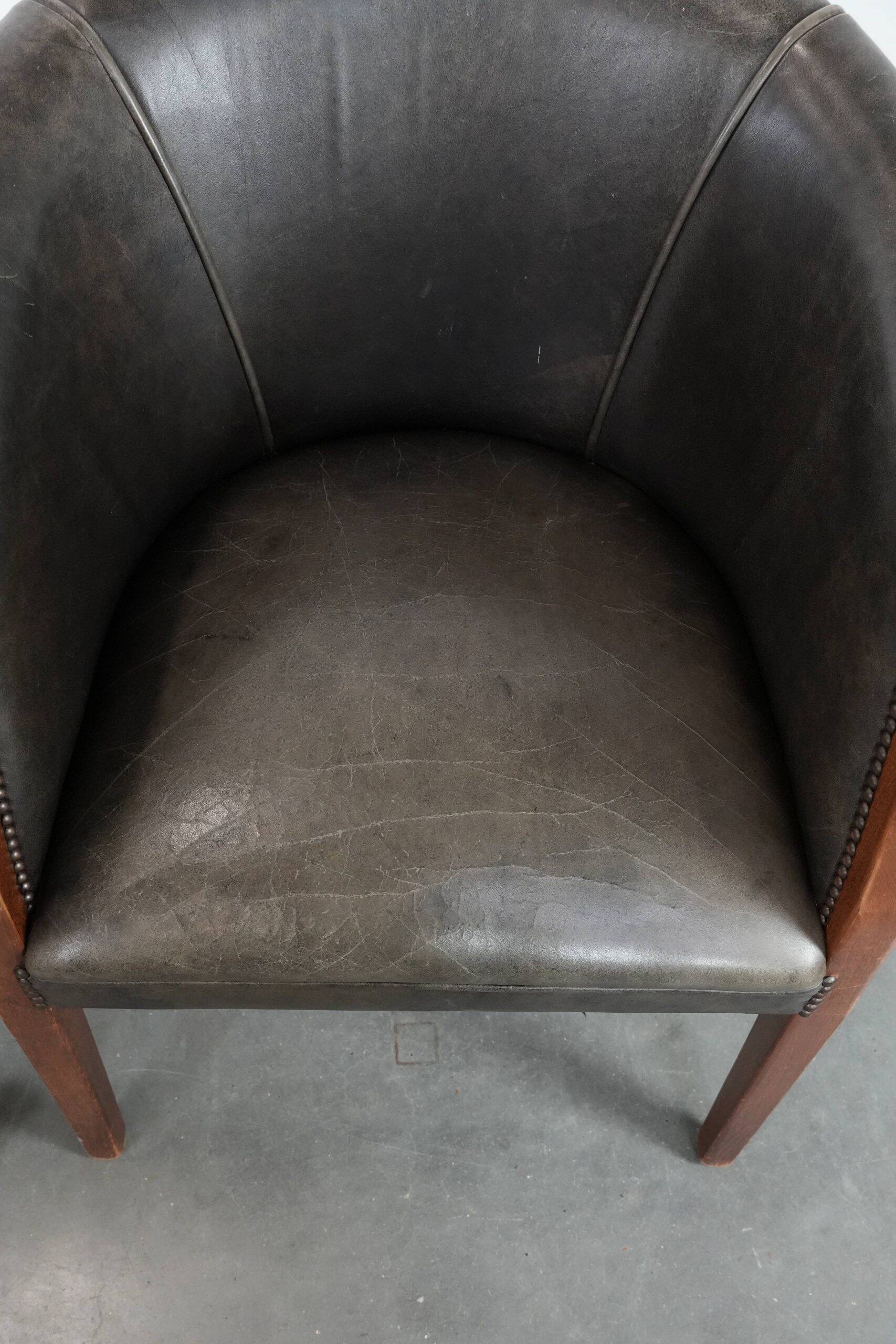 Set of two cowhide and wooden tub chairs with a sturdy colour scheme