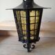 Large hanging lantern in wrought iron and opaque yellow-orange windows
