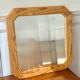 Octagonal mirror in light wood with grooves.