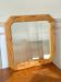 Octagonal mirror in light wood with grooves.