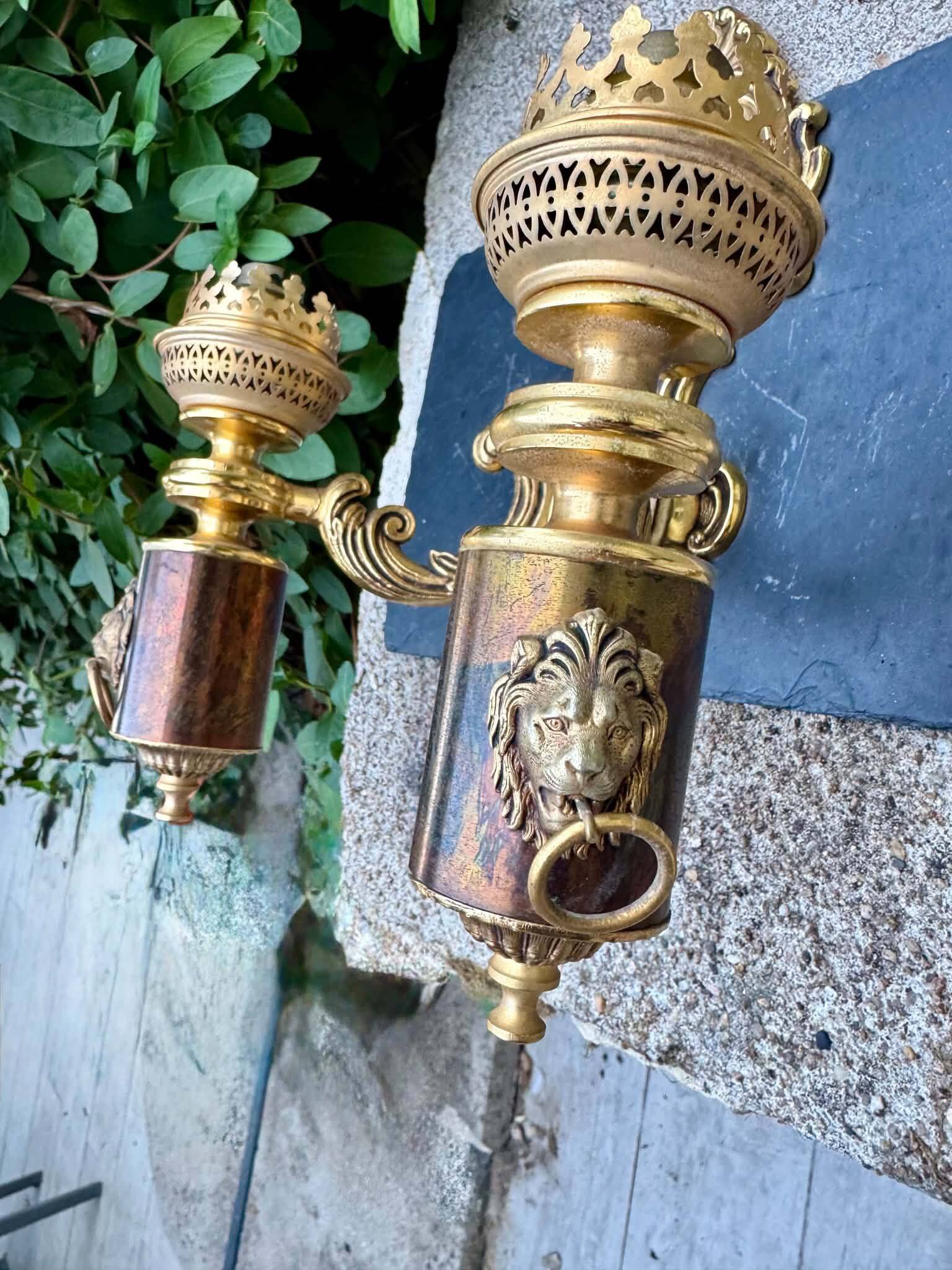 Wall light with 2 branches in baroque brass lion design.