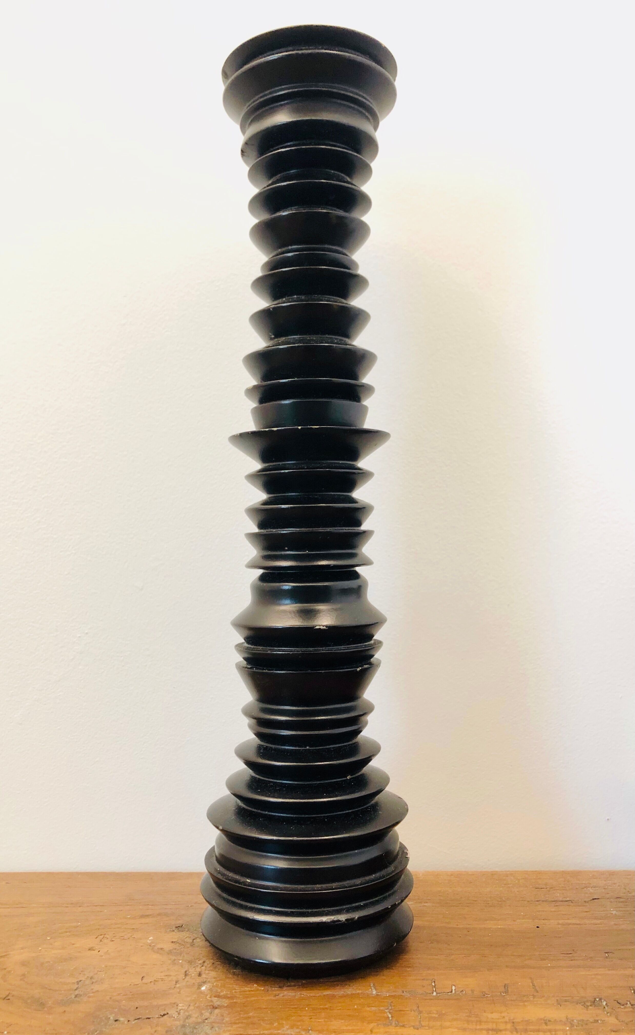 A brutalist black pepper mill