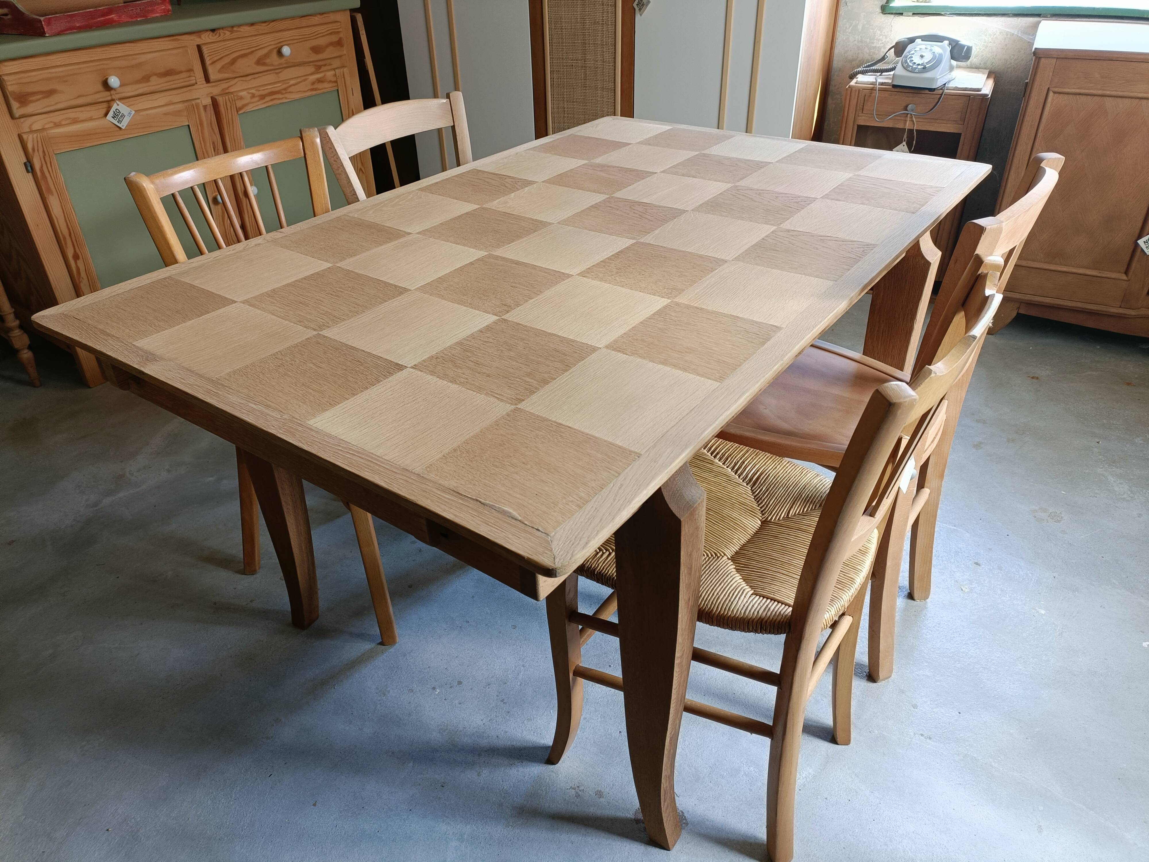 Oak dining table with a checkerboard top and extensions.