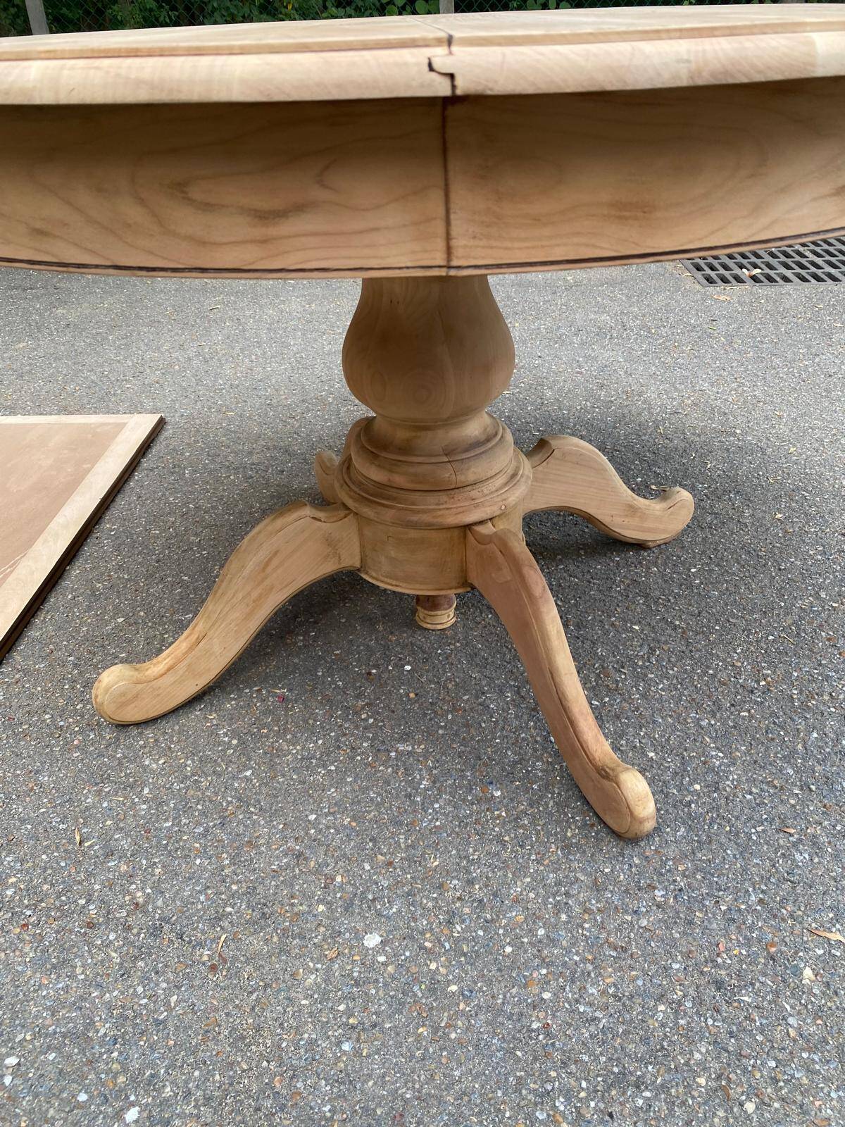 Round dining table with a central pedestal, extendable, stripped in solid walnut with 2 extensions.