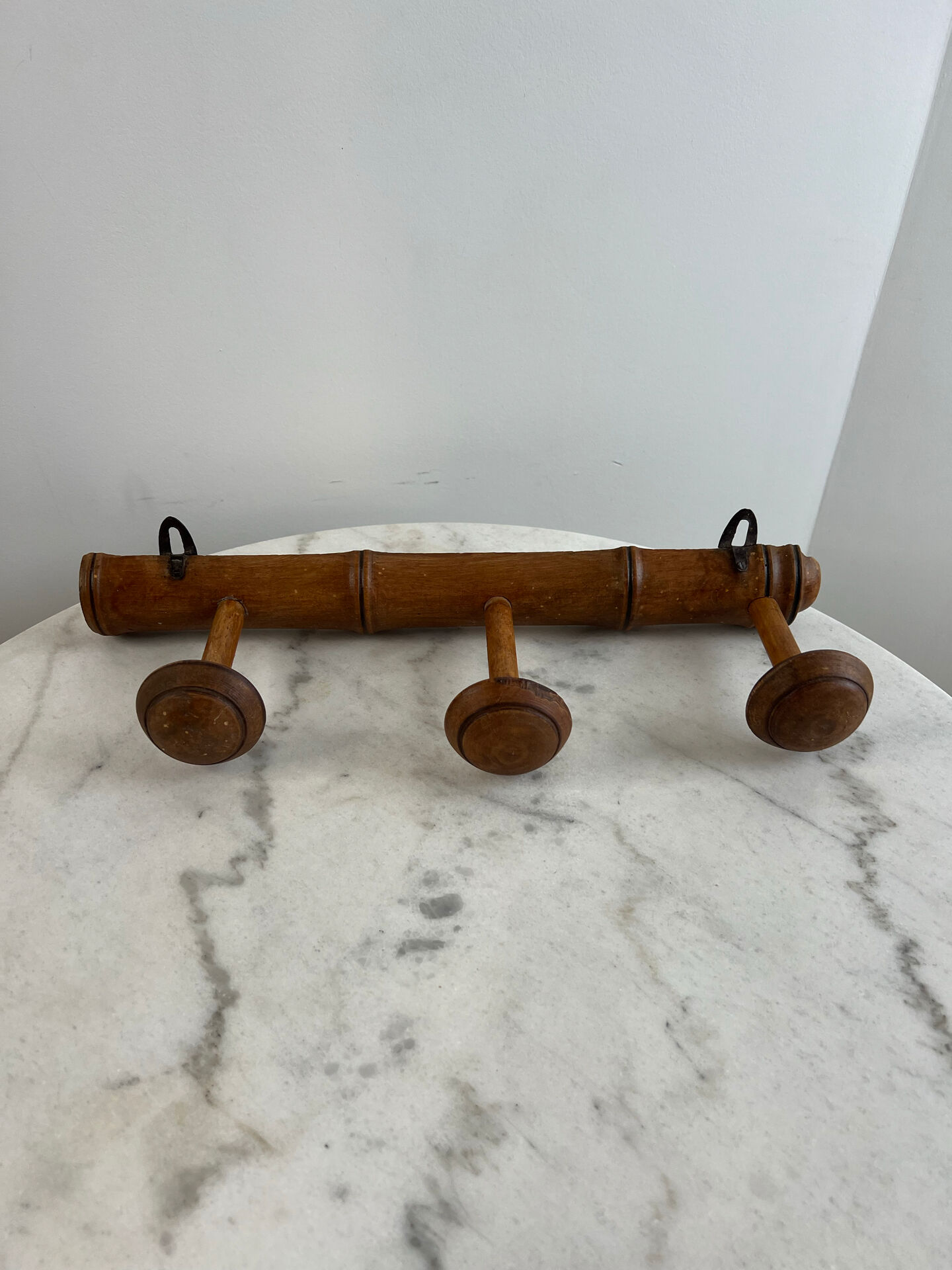 Wooden coat rack with three ball hooks.
