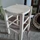 Vintage wooden stool with white peeling paint